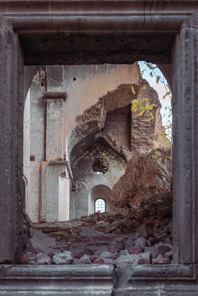 Looking through a stone doorway into an abandoned building
