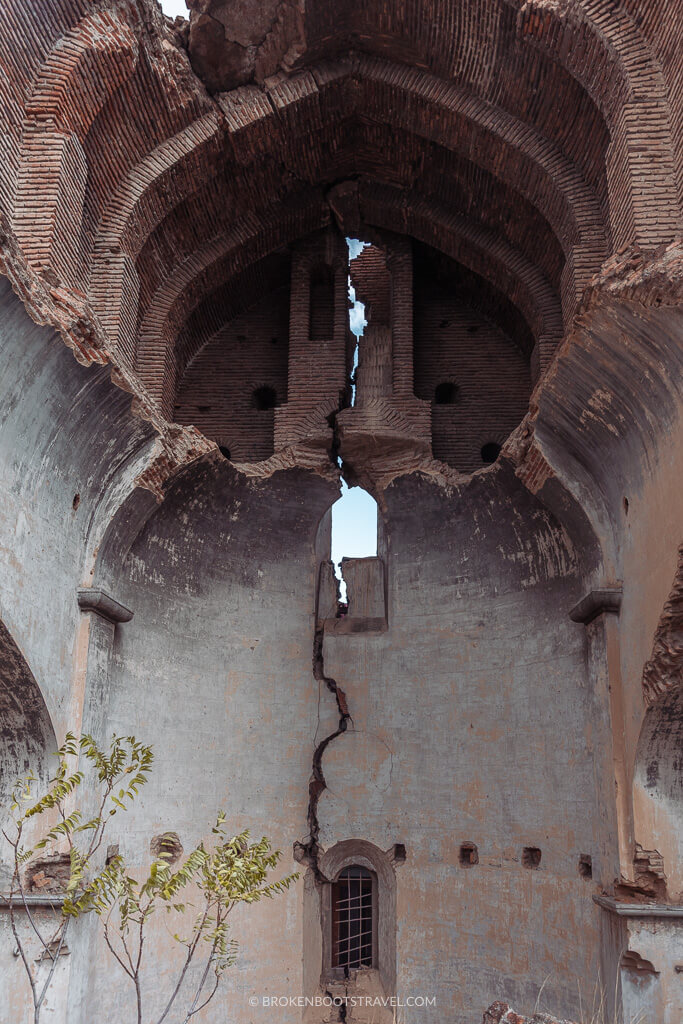 A large crack up the back wall of an abandoned building