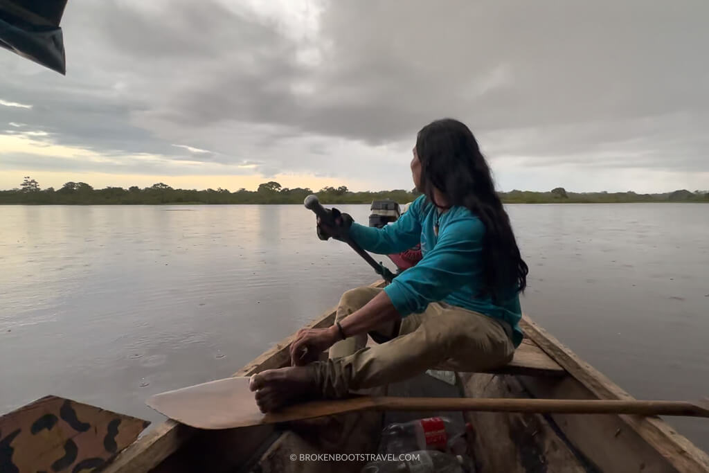 Man in a blue shirt driving a boat on the Amazon River
