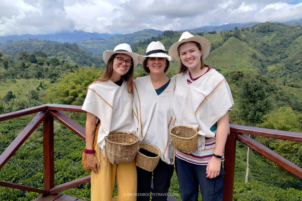 3 Women wearing ponchos and hats on a coffee farm in Colombia