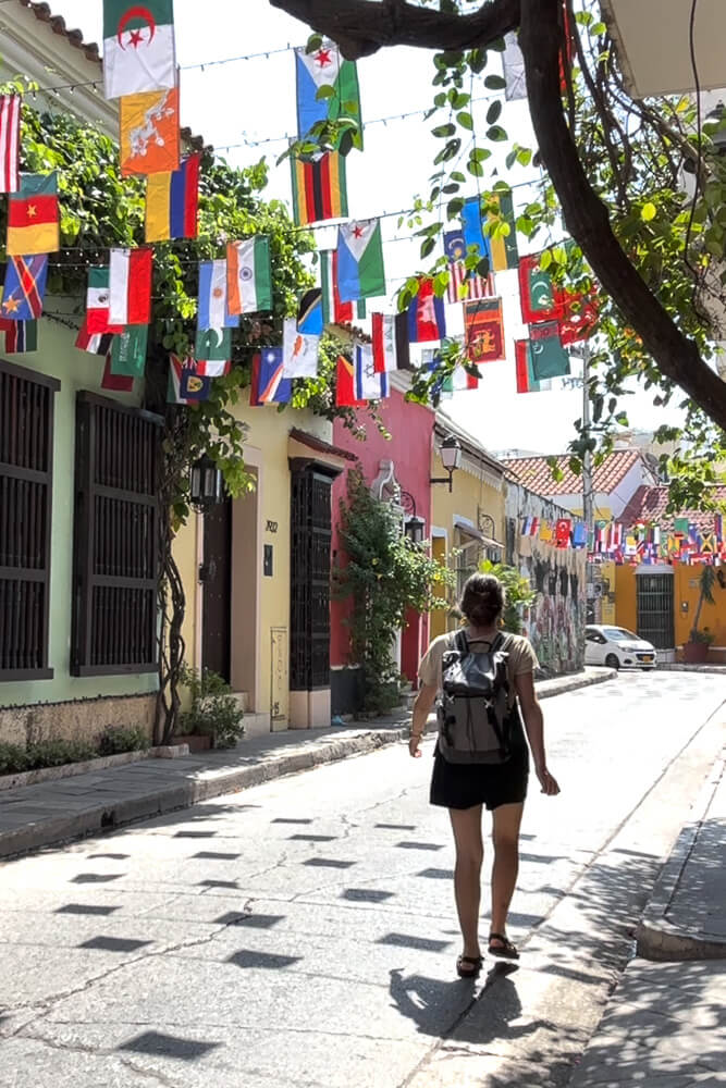 Girl in backpack walking down colorful street