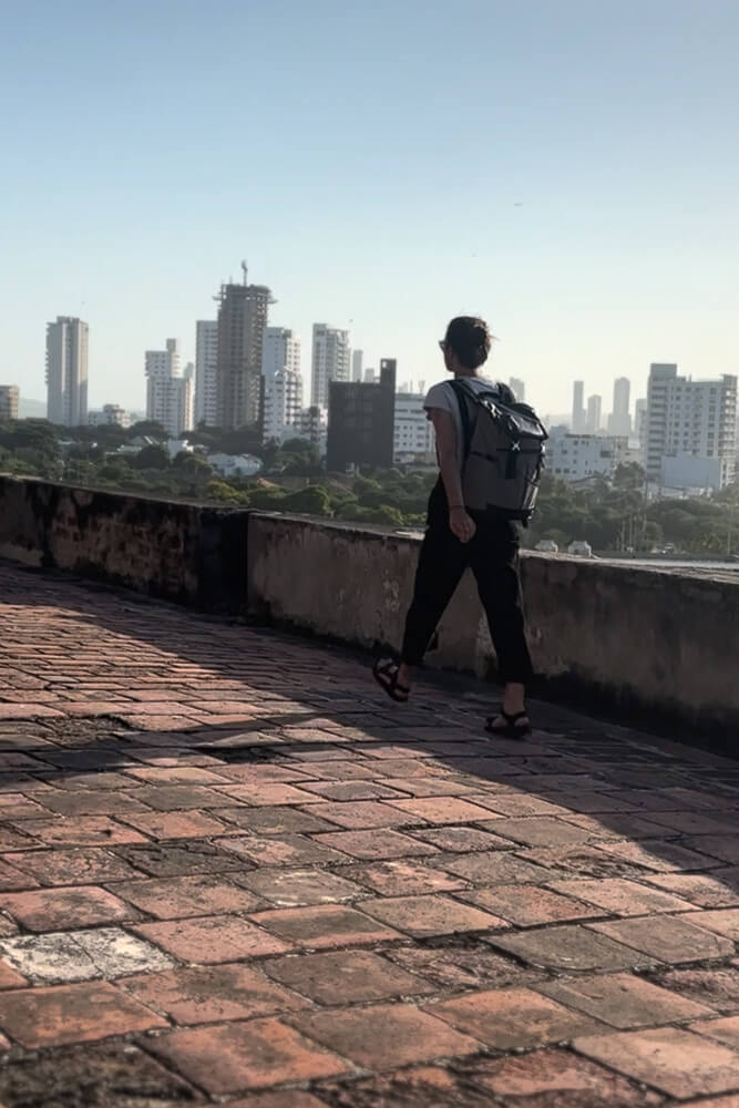 Girl wearing backpack walking along El Castillo de San Felipe