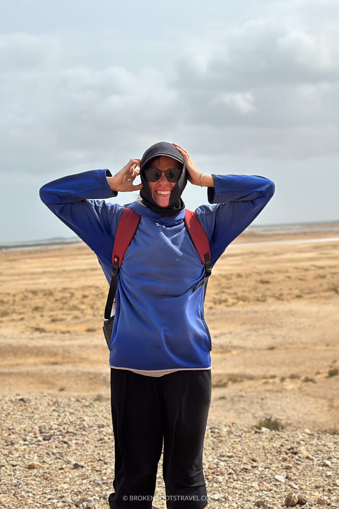 Girl in blue sweatshirt smiling in front of desert