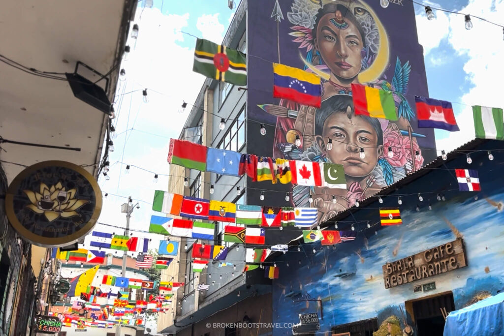 Street in La Candelaria, Bogota Colombia with murals and flags from different countries.