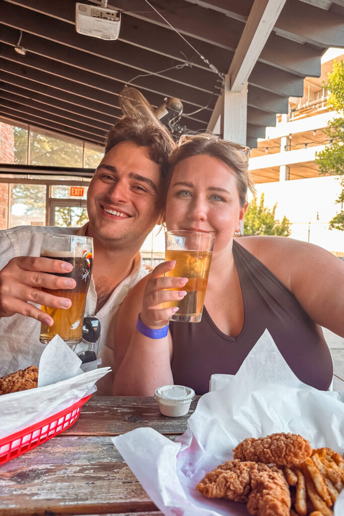 Two people smiling and holding beer glasses 