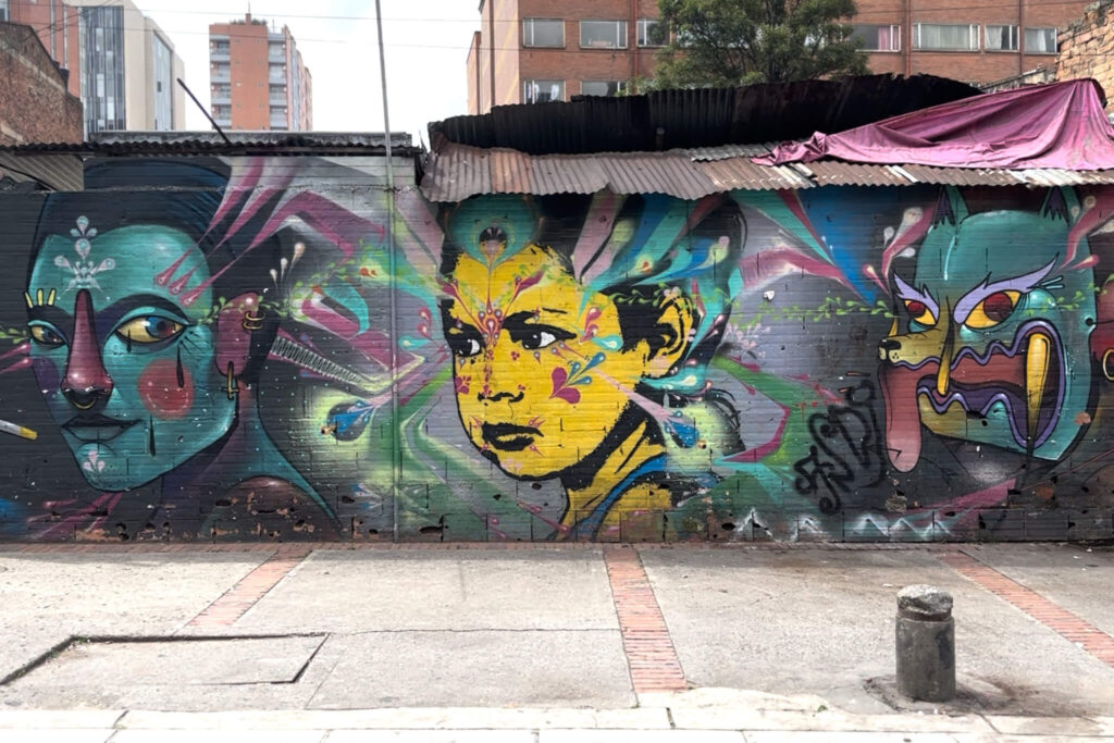 Street art in downtown Bogota, Colombia featuring three paintings of faces