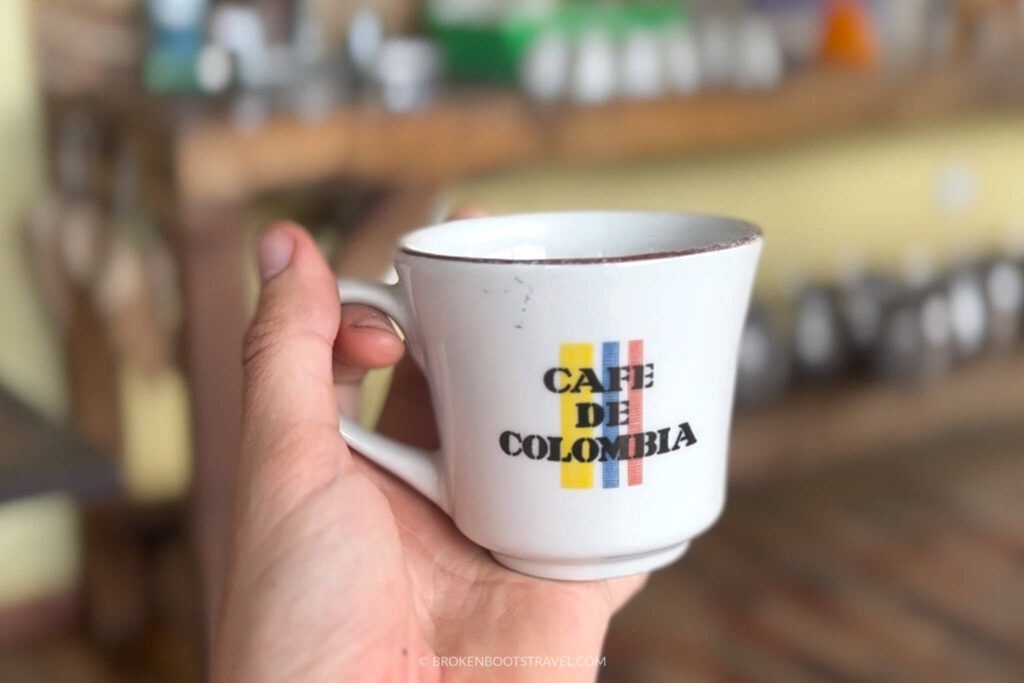 Hang holding a white coffee cup that reads "Cafe de Colombia" with the Colombian flag