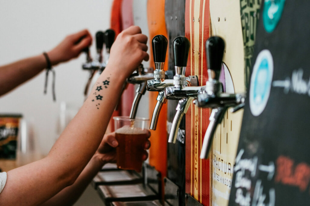 Hands pouring beer from colorful taps