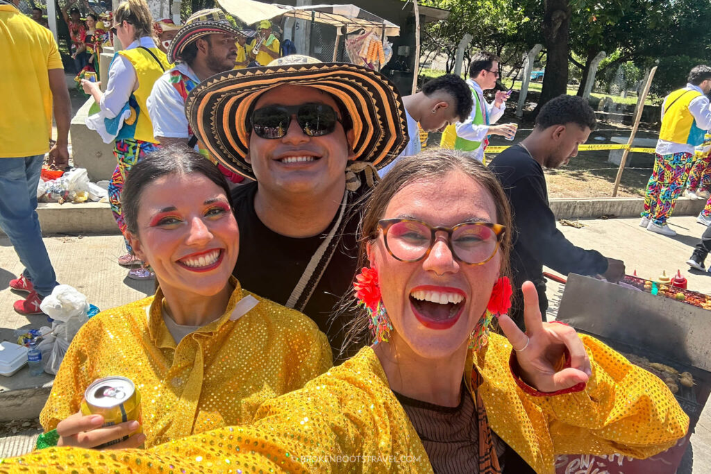 Three people smiling, two women in yellow shirt and a man in a black and white hat