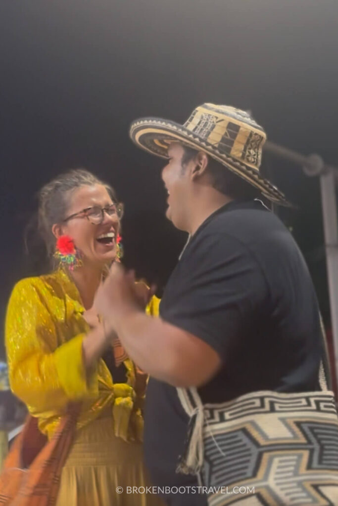 Girl in yellow shirt and man in black shirt and sombrero vueltiao dancing in the street