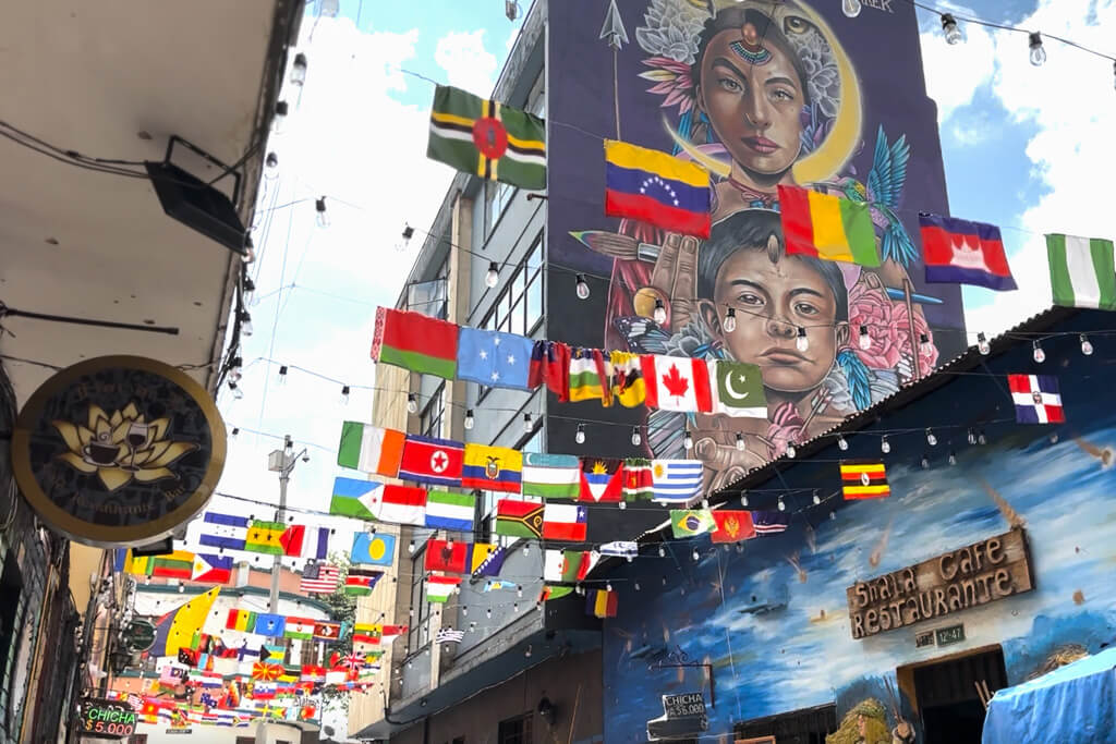 Colorful street covered in murals and flags from different countries bogota medellin itinerary