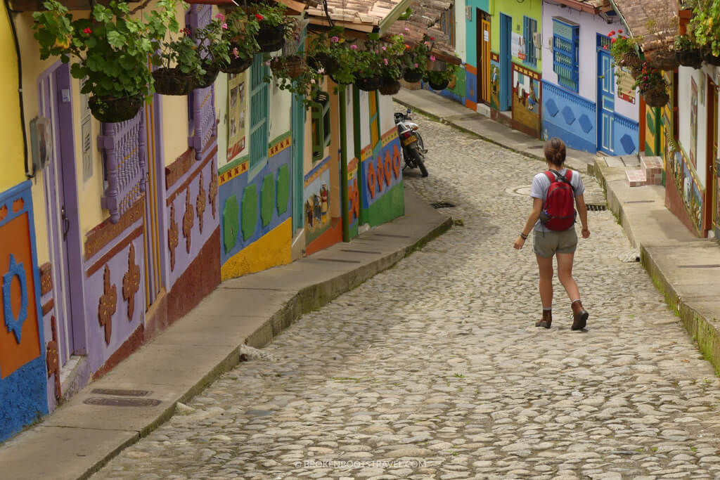 Girl walking down colorful Calle del Recuerdo in Guatape, Colombia