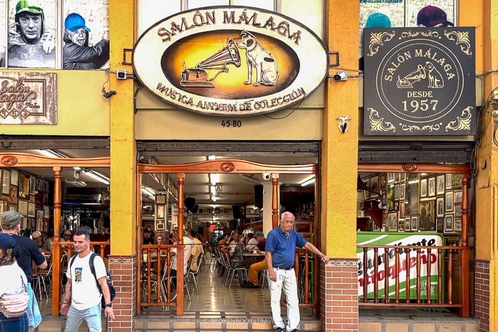 A man in a blue shirt outside of Salon Malaga in Medellin, Colombia
