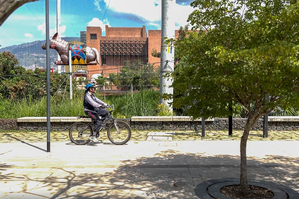 Woman rides a bike in Parques Del Rio, Medellin