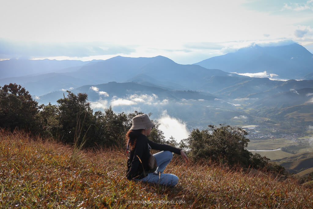 Woman in brown hat, black shirt, and jeans looking over Urrao, Antioquia