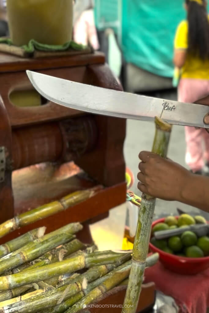 Machete slicing a sugar cane for jugo de caña