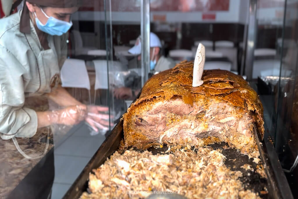 Woman cutting lechona, traditional Colombian food
