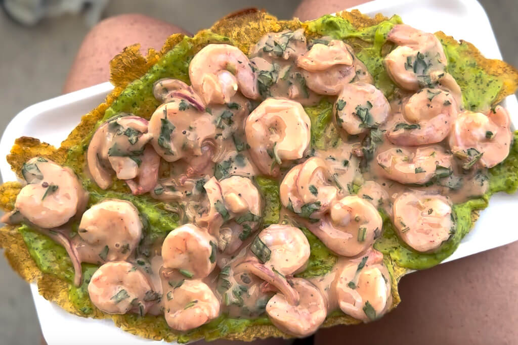 A patacon topped with guacamole and shrimp