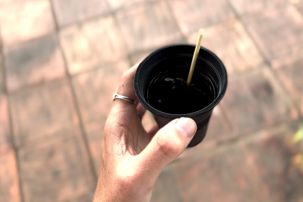 Hang holding a cup of tinto Colombiano