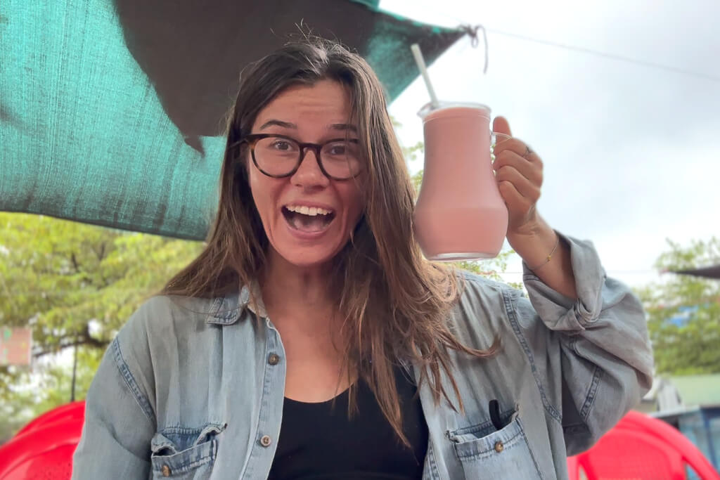 Girl in blue shirt holding up a jar of juice