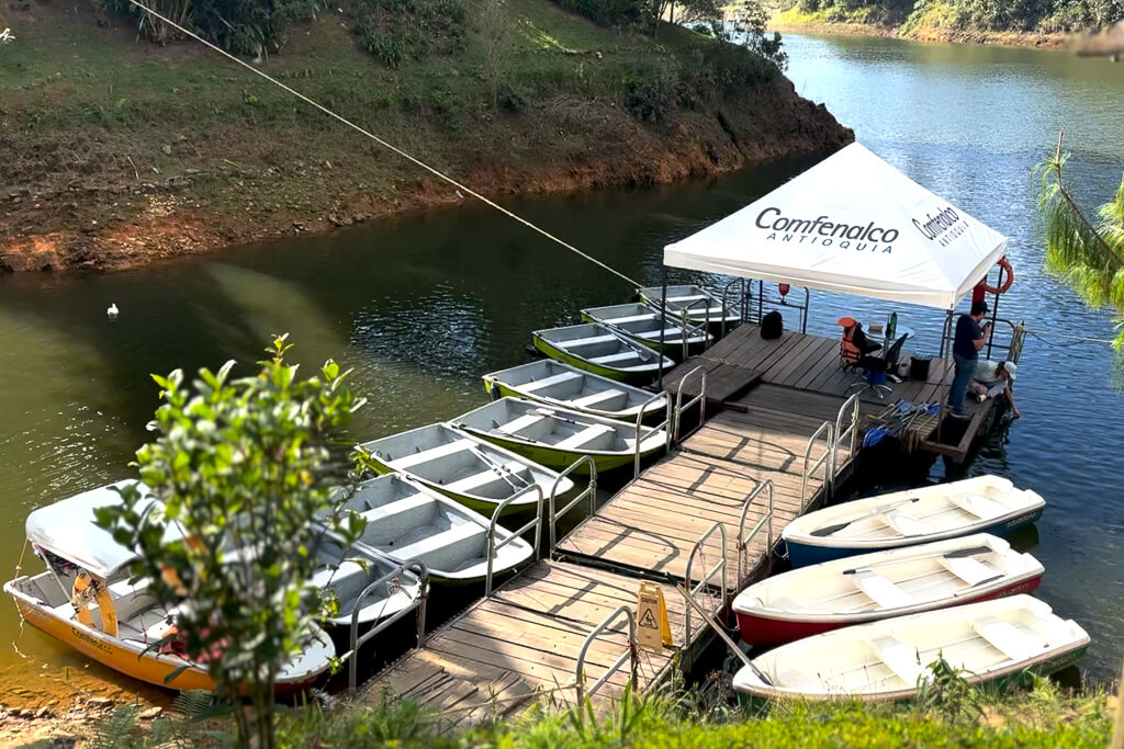 Boats on a lake with white tent reading "Comfama"