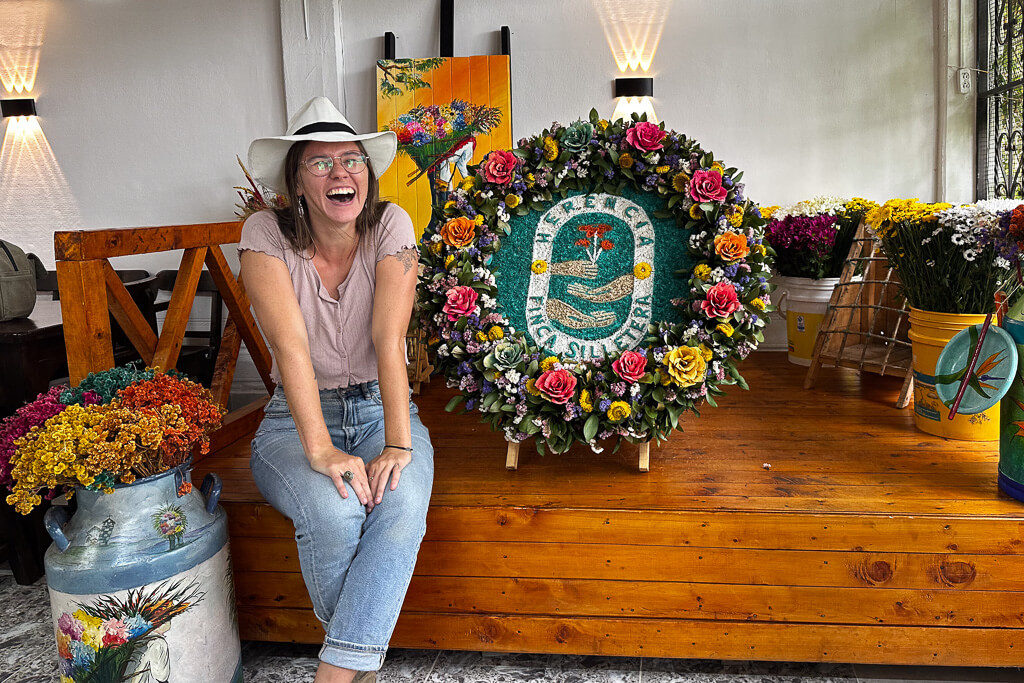 Girl in pink shirt and aguadeño hat posing by silleta at Finca Herencia, Santa Elena, Antioquia