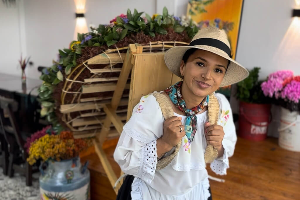 Silletera woman in traditional outfit holding a silleta at Finca Herencia, Santa Elena