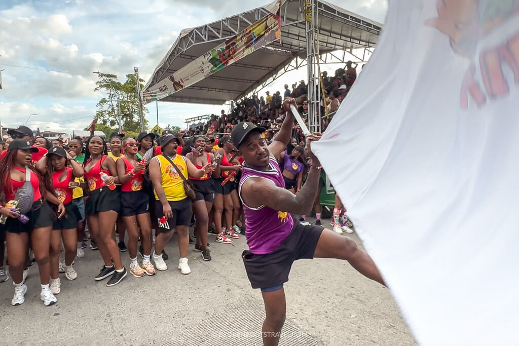 A man waving a flag followed by a parade of dancers at the San Pacho Festival