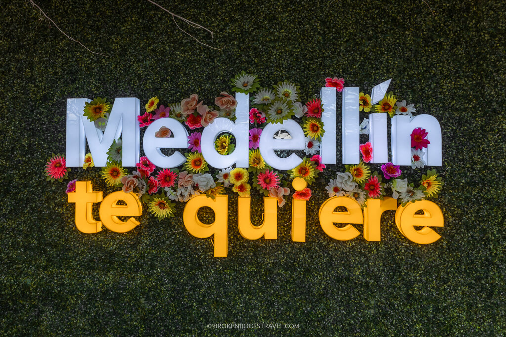 Sign reading "Medellín te quiere" with flowers