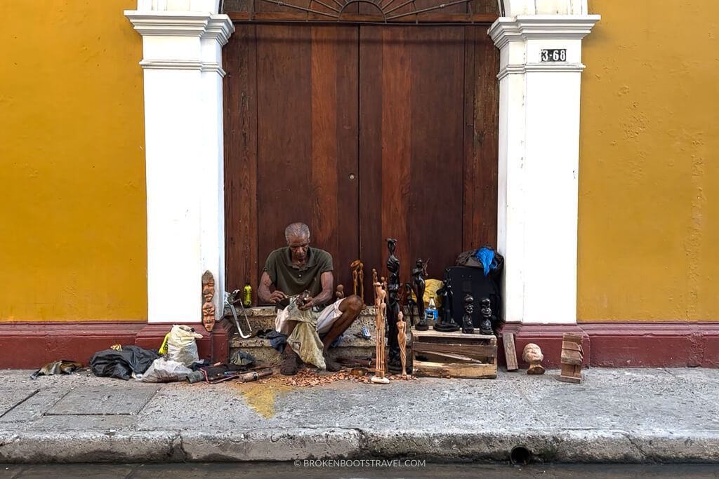 Man making wooden sculptures in the streets of Cartagena, Colombia