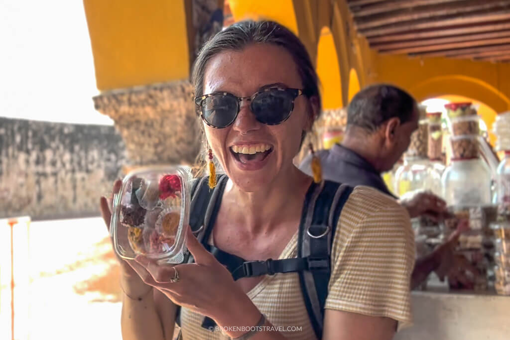 Girl in yellow shirt holding up box of Caribbean sweets